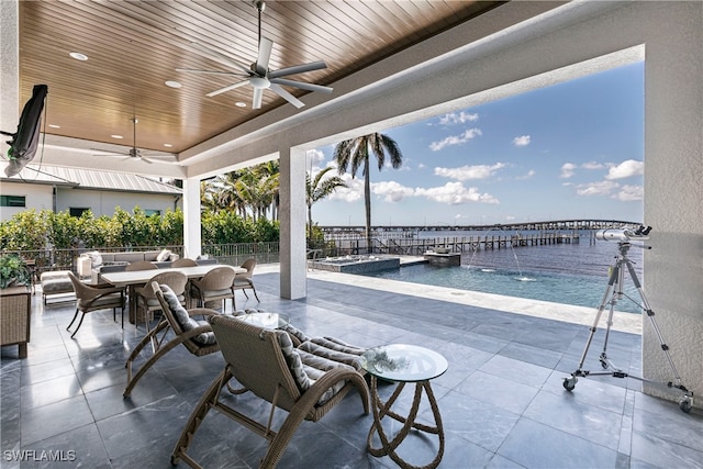 view of patio featuring a water view, ceiling fan, and pool water feature