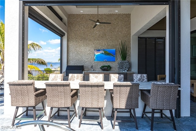 view of patio with an outdoor bar and a water view