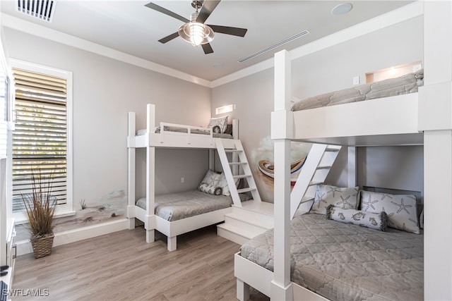 bedroom featuring ceiling fan, ornamental molding, and light hardwood / wood-style flooring