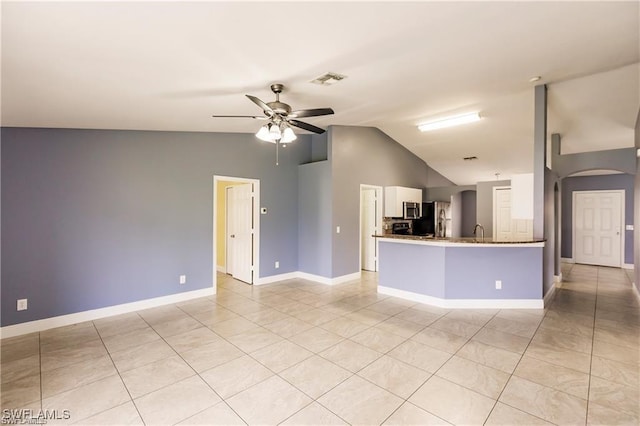 interior space featuring lofted ceiling, sink, light tile patterned floors, and ceiling fan