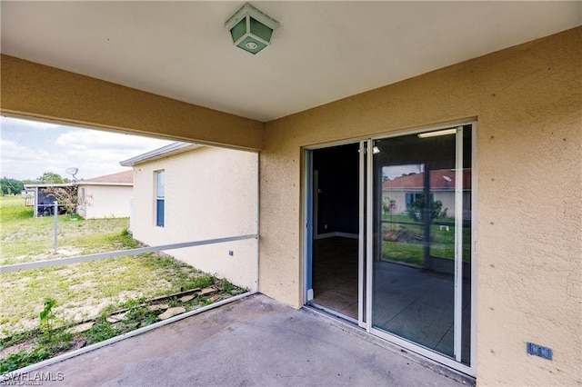 view of exterior entry with a balcony