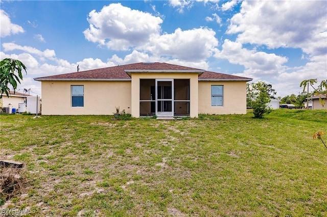 rear view of property featuring a sunroom and a lawn