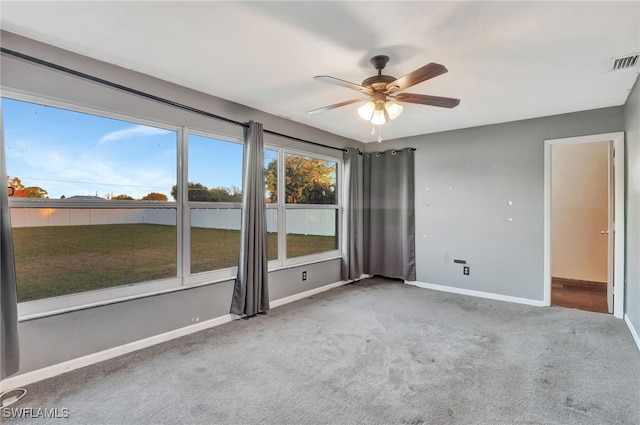 unfurnished room with ceiling fan and carpet