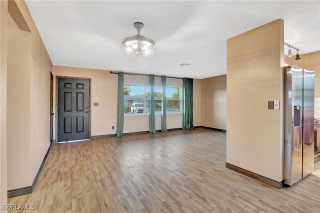 unfurnished room featuring light hardwood / wood-style flooring and rail lighting