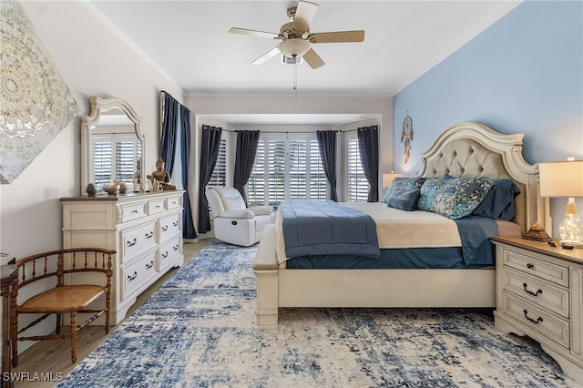 bedroom with light wood-type flooring, a ceiling fan, and crown molding