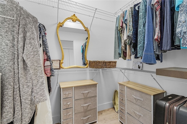walk in closet with light wood-style flooring