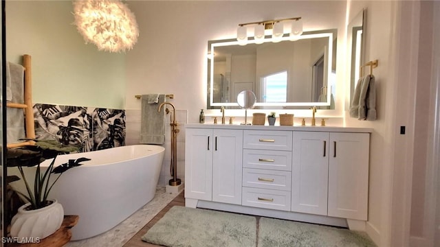 bathroom featuring a soaking tub, a sink, an inviting chandelier, and double vanity