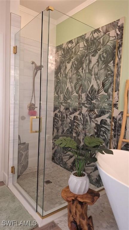 full bathroom with a shower stall and a freestanding bath