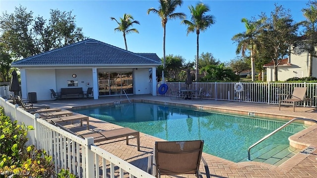 community pool featuring a patio area and fence