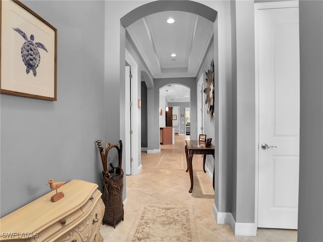 corridor featuring arched walkways, ornamental molding, baseboards, and recessed lighting