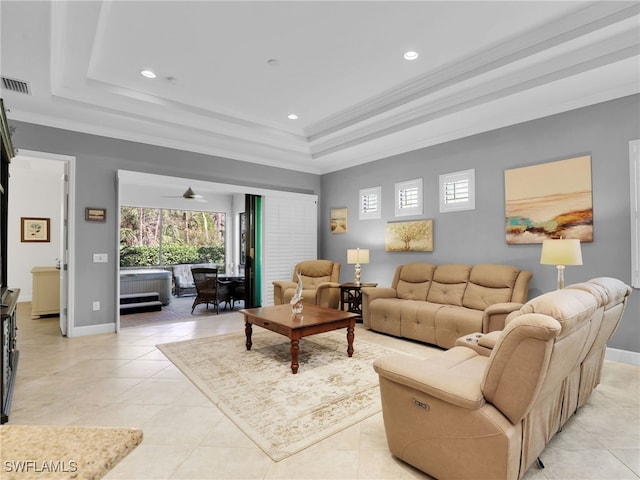 living area with crown molding, a tray ceiling, visible vents, and plenty of natural light