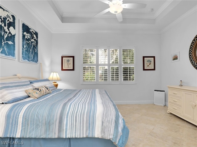 bedroom featuring a tray ceiling, crown molding, baseboards, and ceiling fan