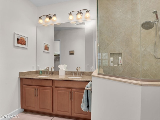 bathroom with double vanity, walk in shower, and a sink