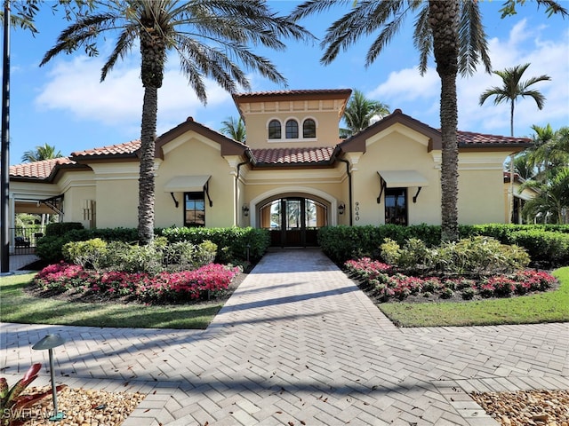 mediterranean / spanish-style home featuring a tile roof and stucco siding