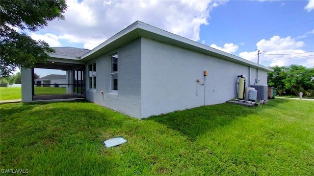 view of side of home with a yard and central air condition unit