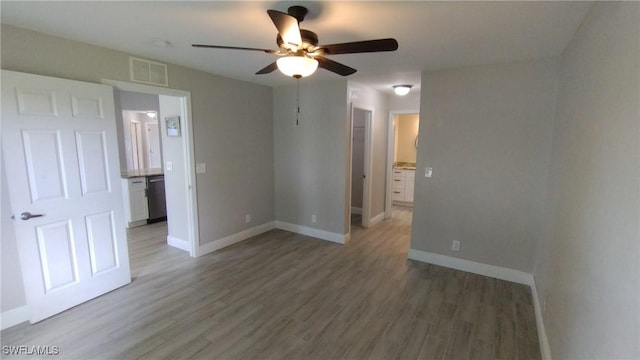 empty room featuring dark wood-type flooring and ceiling fan