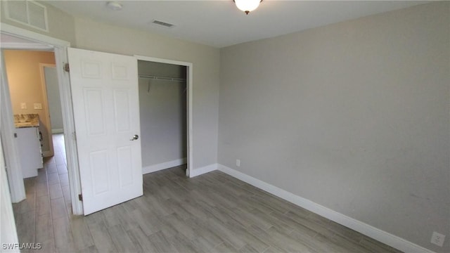 unfurnished bedroom featuring light hardwood / wood-style floors and a closet