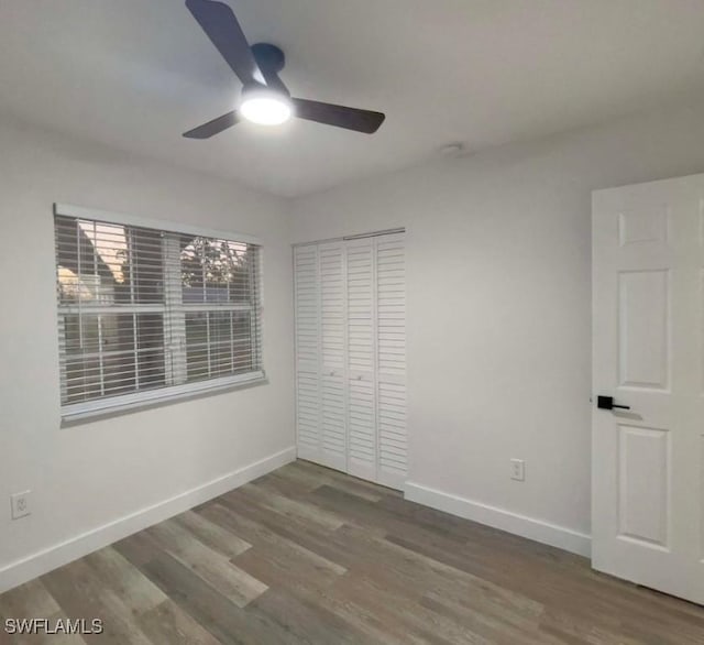 unfurnished bedroom featuring hardwood / wood-style flooring, a closet, and ceiling fan