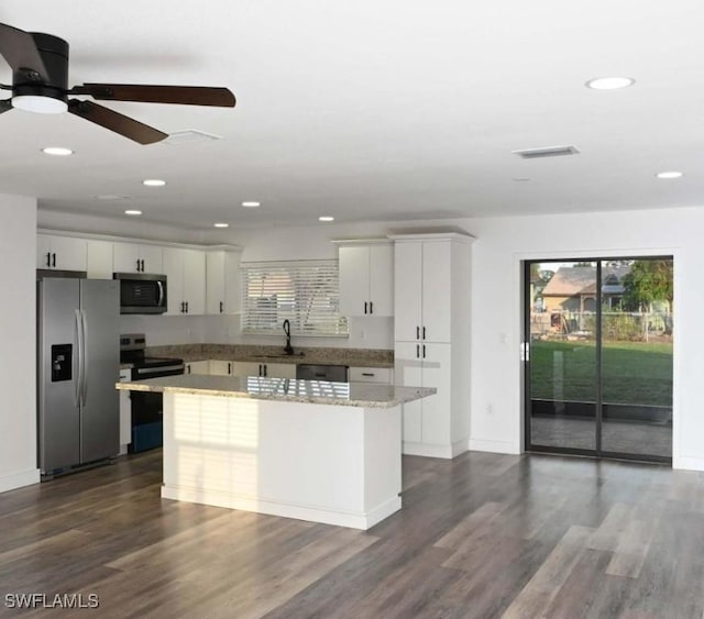 kitchen with white cabinetry, a healthy amount of sunlight, appliances with stainless steel finishes, and a kitchen island