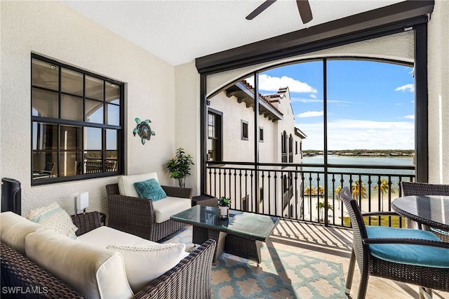 sunroom with a water view and ceiling fan