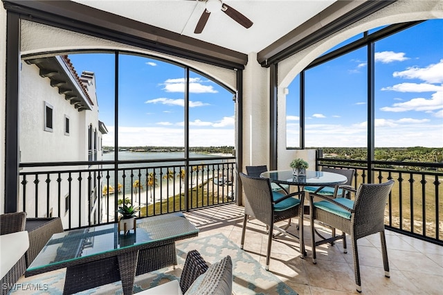 sunroom with a water view, a wealth of natural light, and ceiling fan