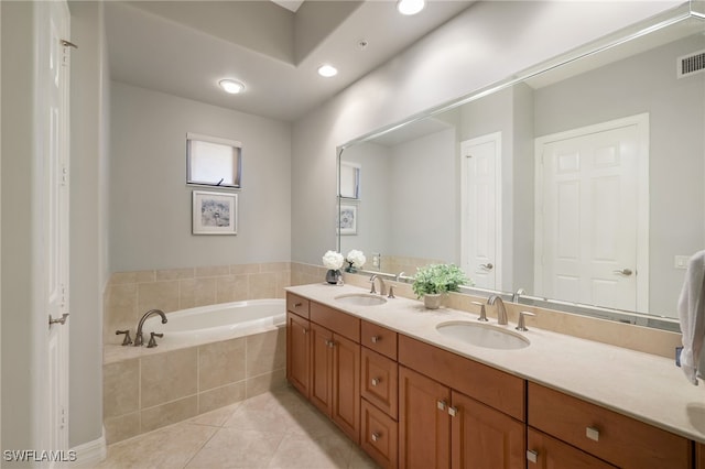 bathroom featuring vanity, tiled tub, and tile patterned floors