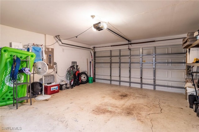 garage with a garage door opener and electric panel