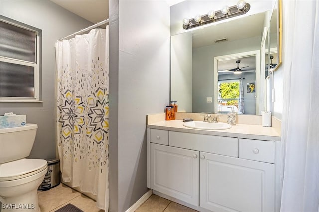 bathroom with ceiling fan, tile patterned flooring, vanity, toilet, and walk in shower