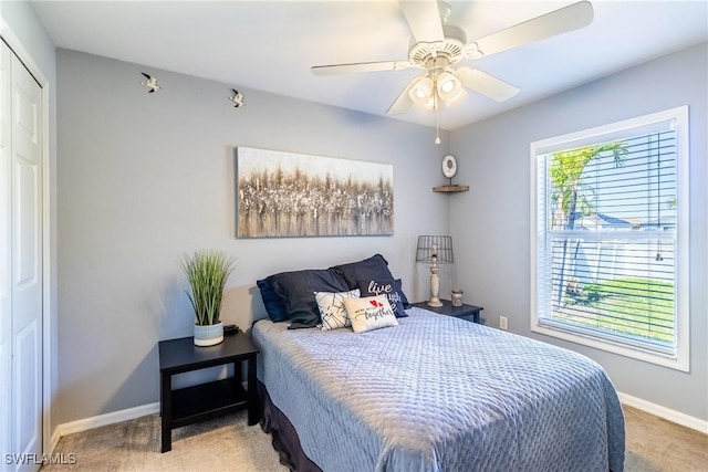 carpeted bedroom with ceiling fan and a closet