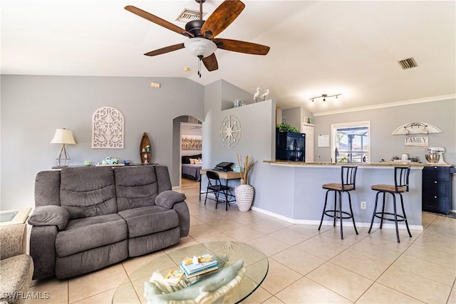 living room featuring vaulted ceiling, light tile patterned floors, and ceiling fan