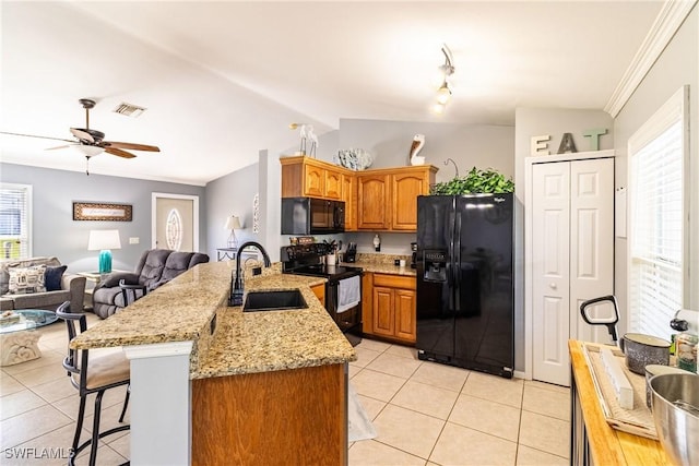 kitchen featuring sink, kitchen peninsula, light tile patterned floors, and black appliances