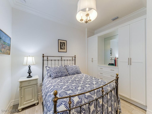 bedroom featuring crown molding and light wood-type flooring