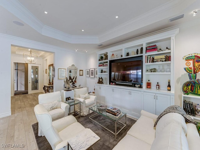 living room featuring crown molding, a tray ceiling, french doors, a chandelier, and light wood-type flooring