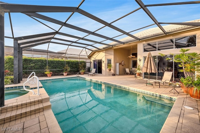 view of swimming pool featuring an in ground hot tub, ceiling fan, a patio, and glass enclosure