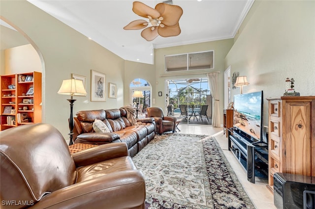 living room with ornamental molding, arched walkways, light tile patterned flooring, and ceiling fan