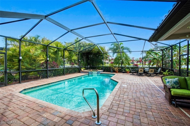 view of swimming pool featuring an in ground hot tub, a patio, and glass enclosure