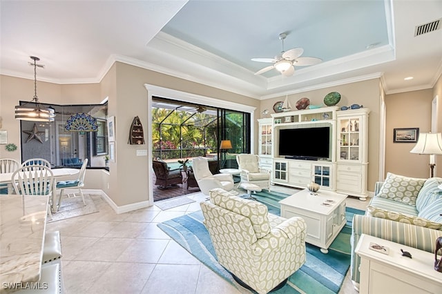 tiled living room with crown molding, a tray ceiling, and ceiling fan