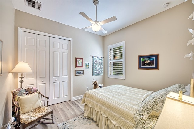 bedroom with light hardwood / wood-style floors, a closet, and ceiling fan