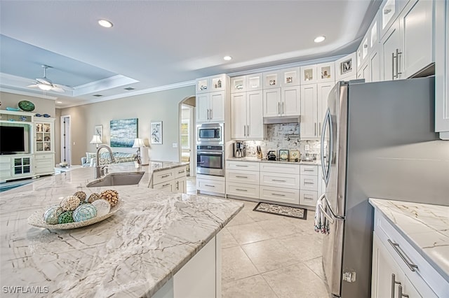 kitchen featuring stainless steel appliances, a raised ceiling, sink, and white cabinets