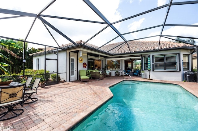 view of pool with a lanai, outdoor lounge area, a patio, and ceiling fan