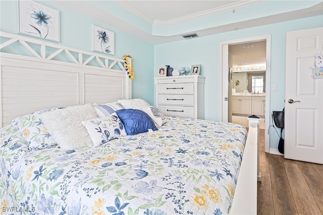 bedroom with dark wood-type flooring, ensuite bath, and ornamental molding