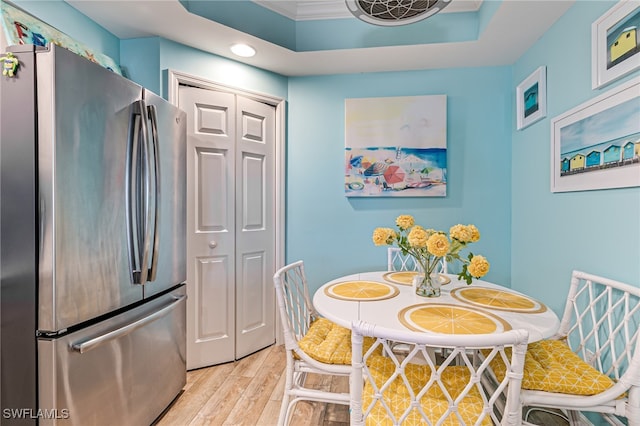 kitchen with crown molding, stainless steel fridge, and light wood-type flooring