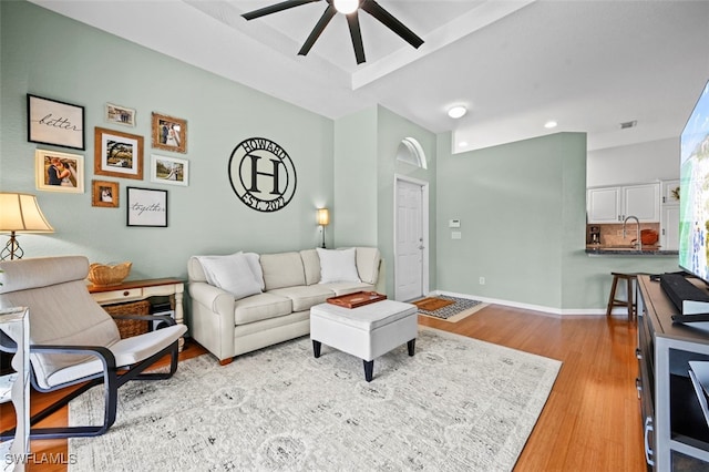 living room featuring ceiling fan and light hardwood / wood-style flooring