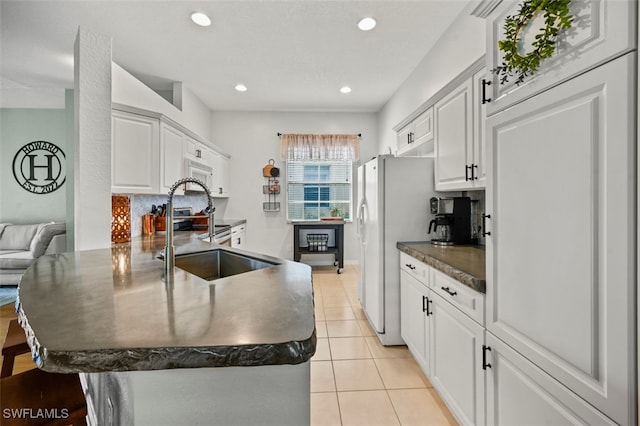 kitchen featuring white cabinetry, sink, light tile patterned floors, and kitchen peninsula