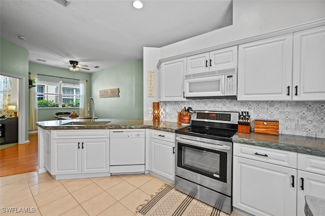 kitchen with sink, white appliances, kitchen peninsula, and white cabinets