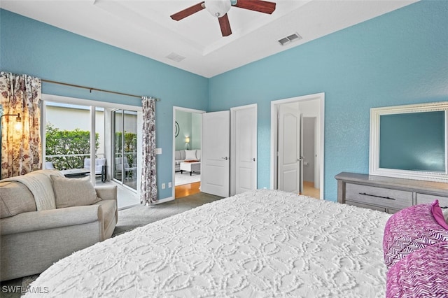 bedroom featuring ceiling fan, carpet flooring, a tray ceiling, and access to exterior