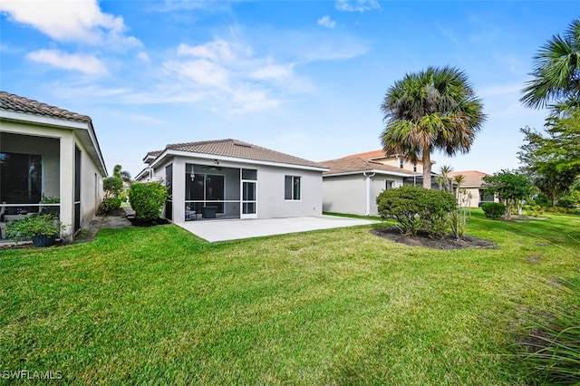 rear view of property with a sunroom, a lawn, and a patio area