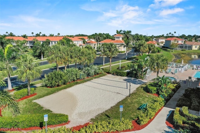 view of home's community with volleyball court and a water view