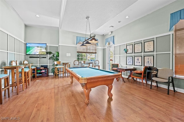 playroom featuring pool table, light hardwood / wood-style floors, and a textured ceiling