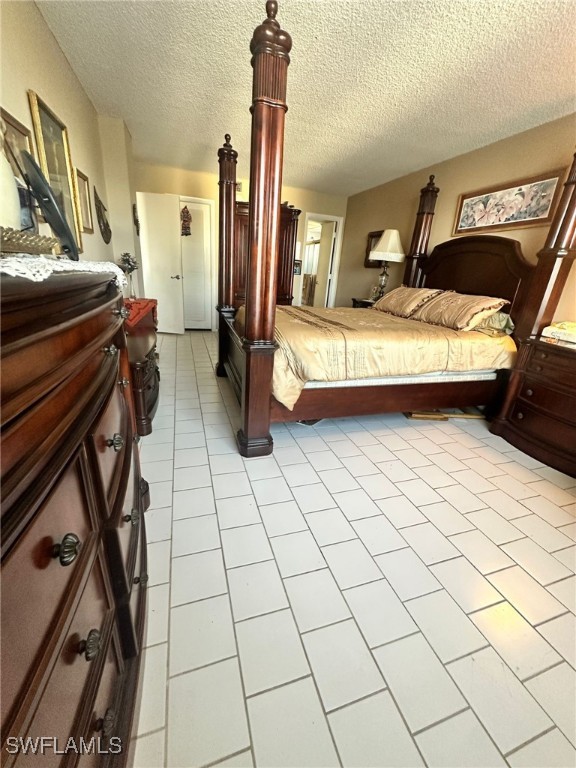 bedroom featuring a textured ceiling and light tile patterned floors